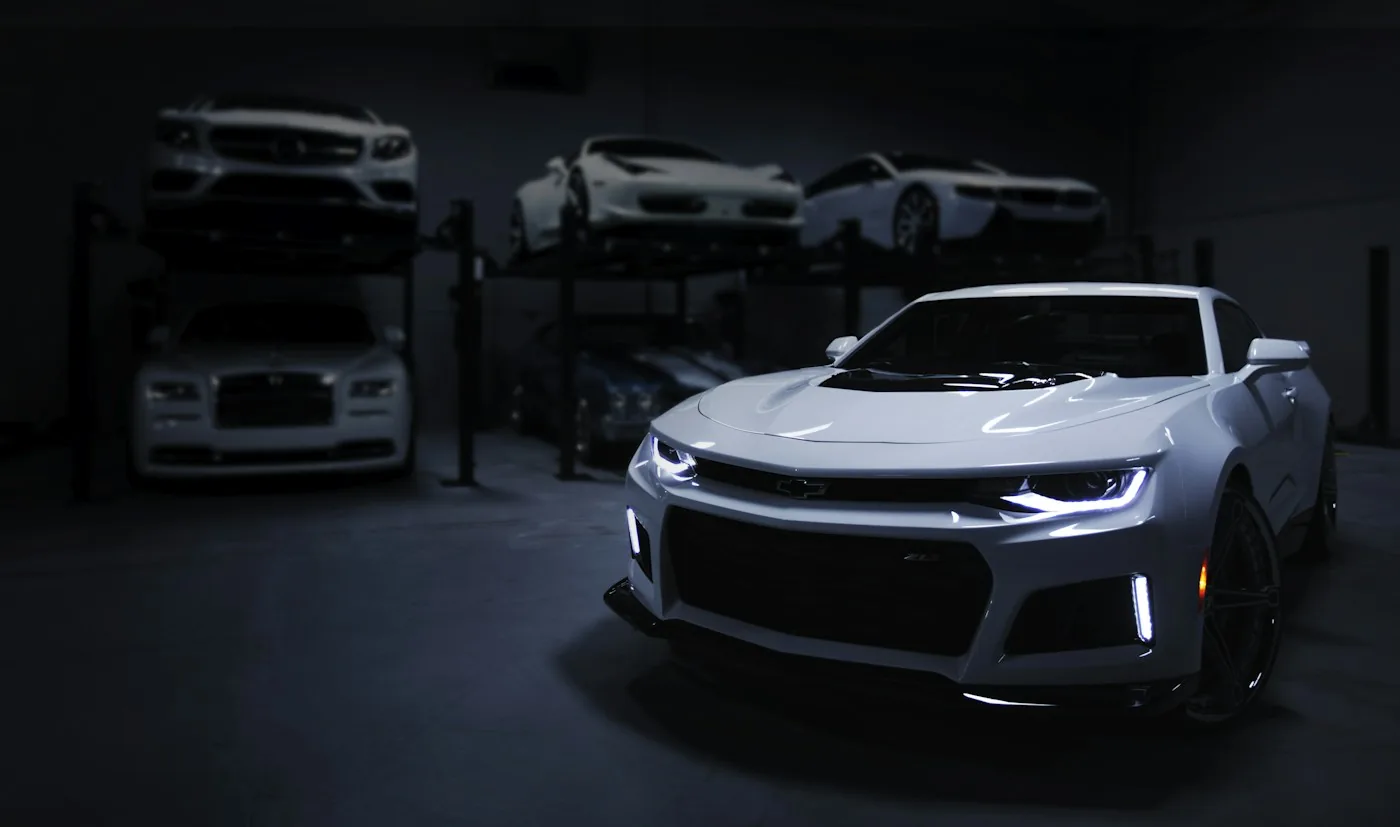 Silver Chevrolet Camaro in a dark automotive workshop
